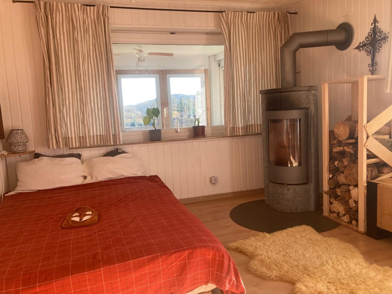 Gemütlicher Innenraum mit Bett und Kaminofen