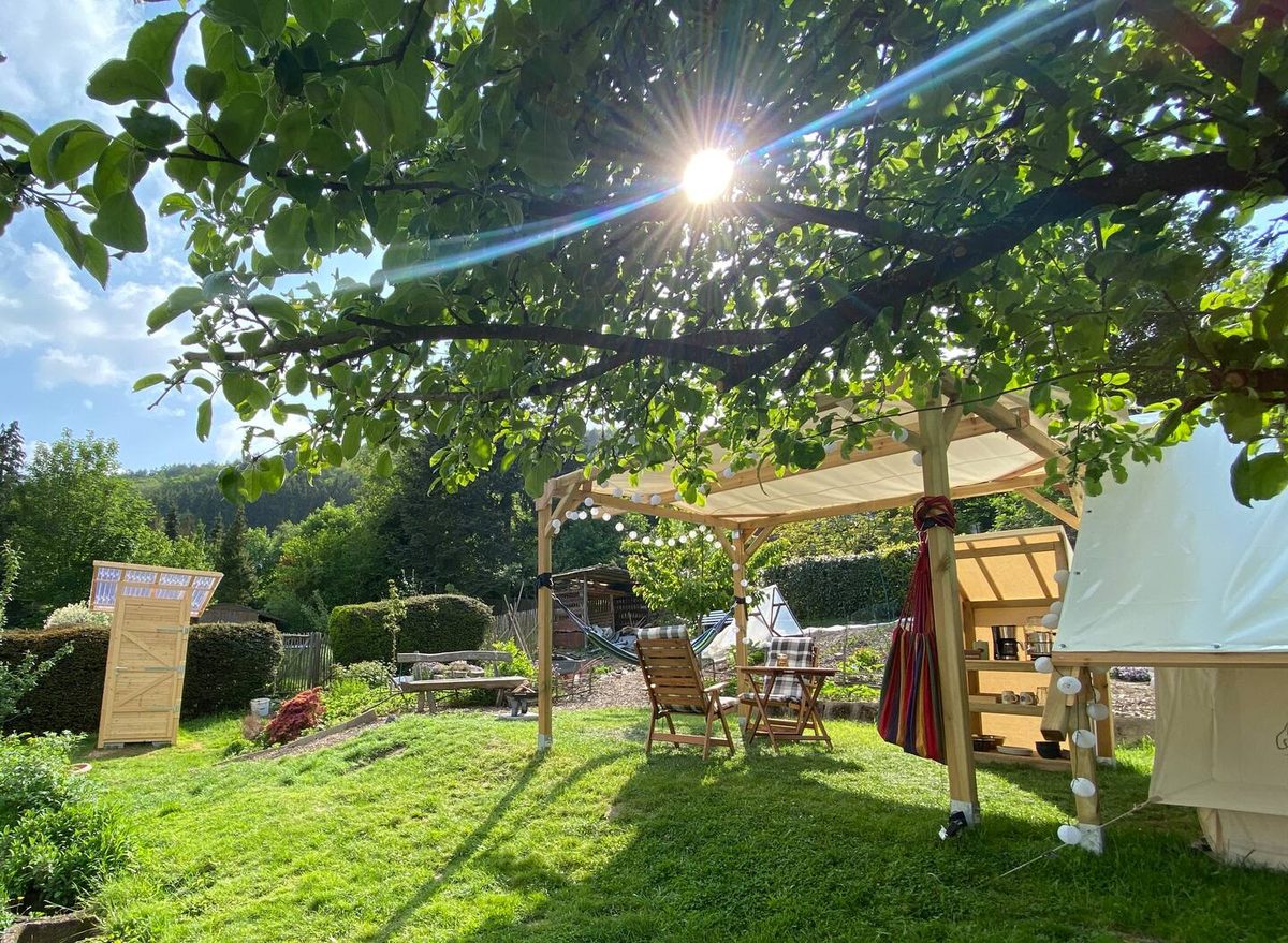 Glamping-Zelt im Garten unter Bäumen